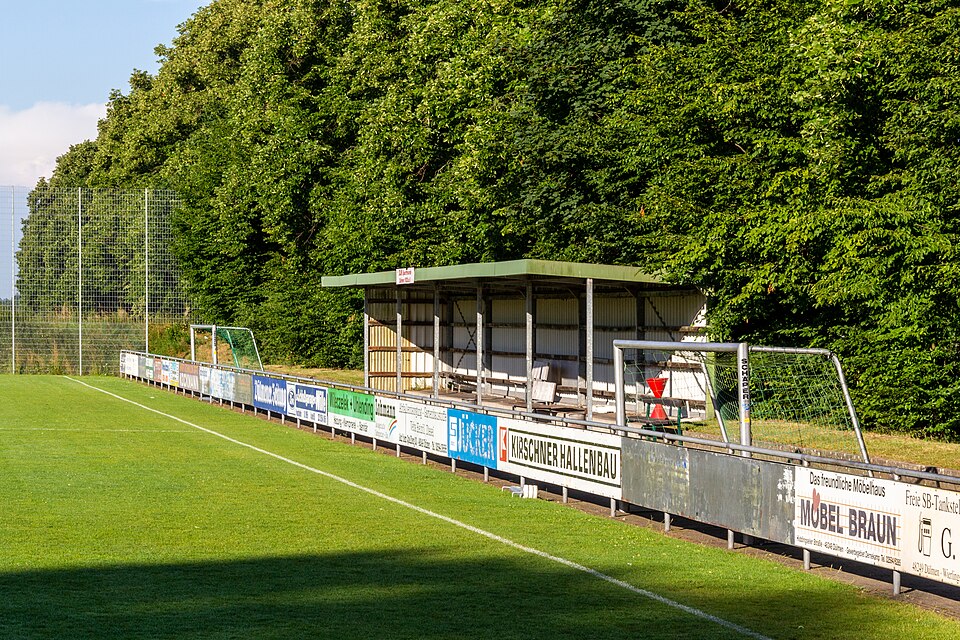 Aficionados viendo fútbol en un bar deportivo durante la noche